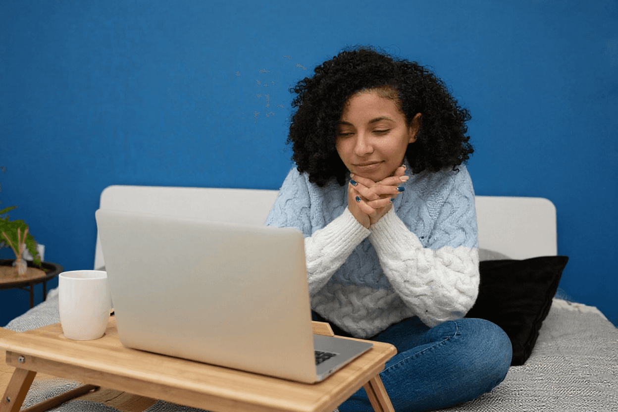 Woman with curly hair looking at laptop